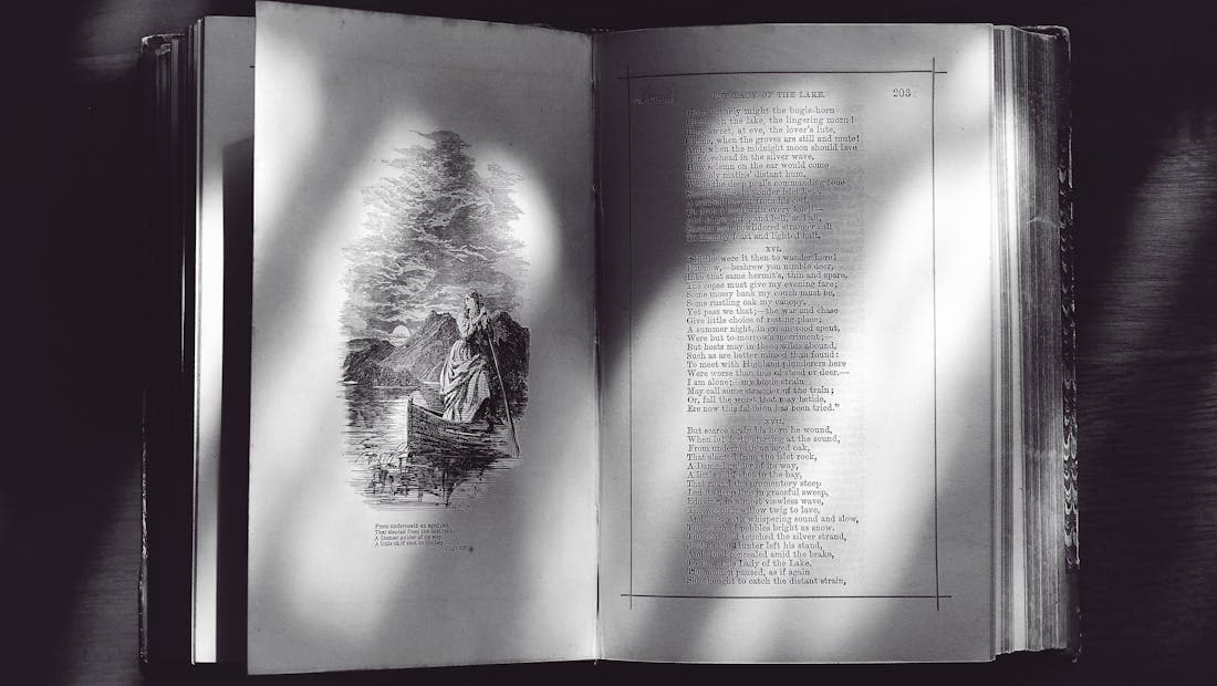 An old open book with handwritten text and an illustration
