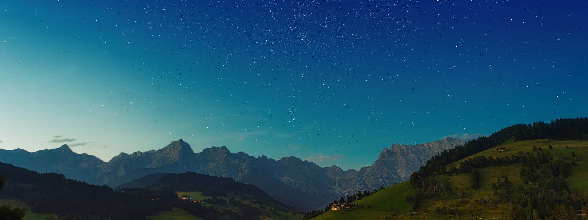 Night sky full of stars over rolling hills